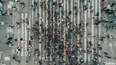 Vista dall'alto di una folla di persone che attraversa un passaggio pedonale