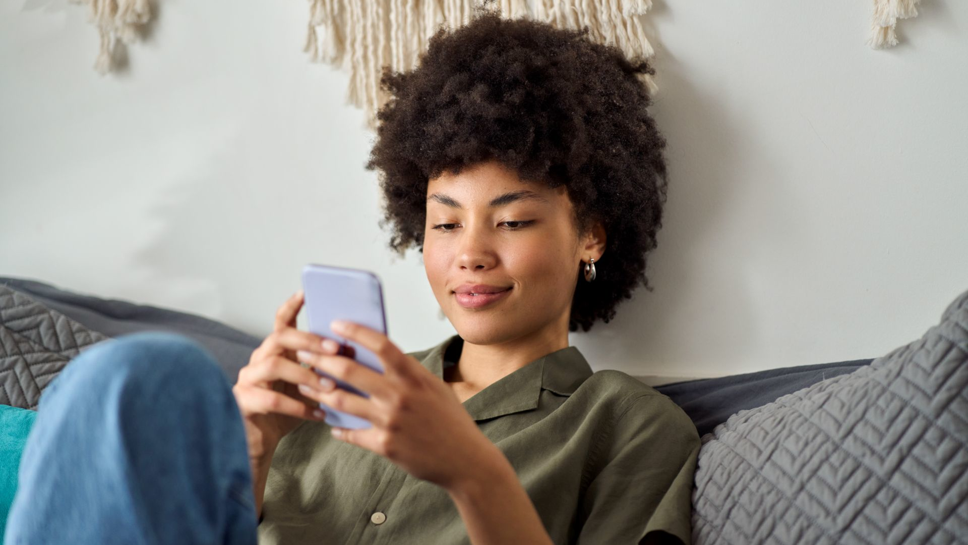 Giovani donne afroamericane che usano lo smartphone a casa.