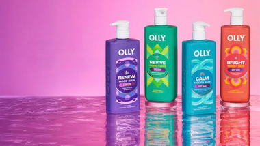 Flaconi colorati di bagnoschiuma Olly Mood + Skin su sfondo rosa, progettati per migliorare umore e benessere.