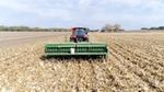 Un agricoltore su un trattore che lavora alle coltivazioni
